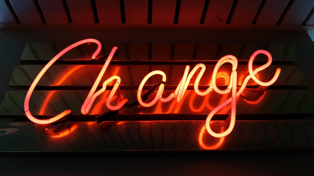 Orange fluorescent light in cursive that says "Change"