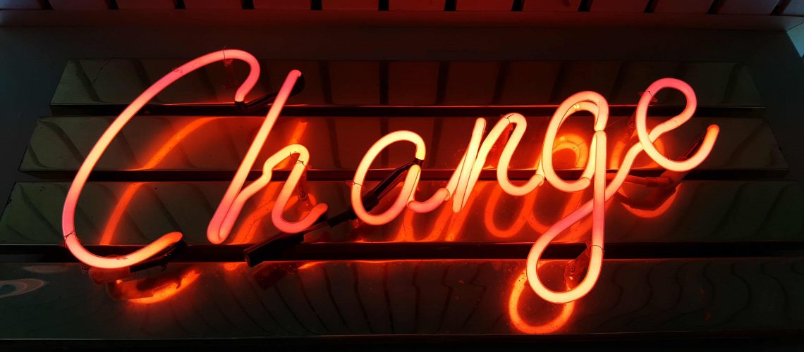 Orange fluorescent light in cursive that says "Change"